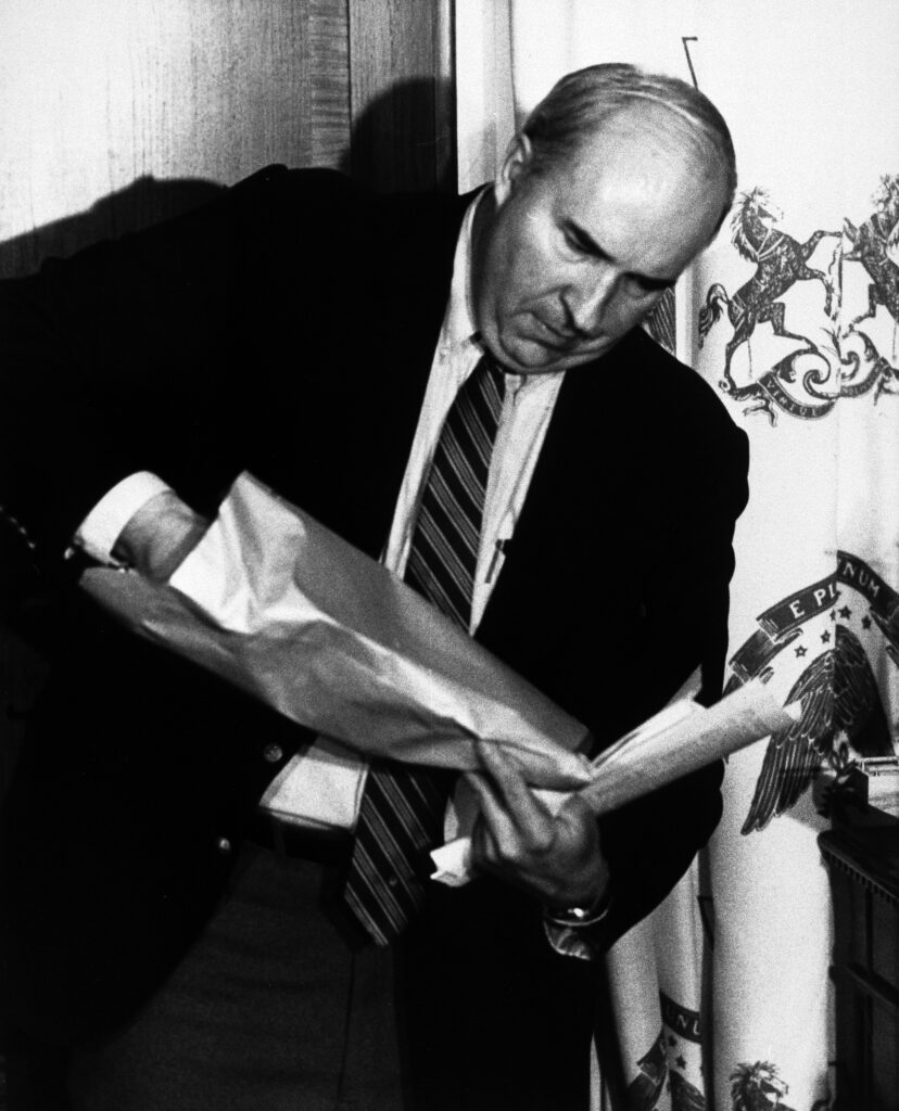 Pennsylvania state treasurer R. Budd Dwyer prepares to pull a pistol from a brown manila envelope during a news conference in his State Capitol office in Harrisburg, Penn., Jan. 22, 1987. Dwyer inserted the pistol barrel into his mouth and pulled the trigger, committing suicide in front of newsmen. (AP Photo/Paul Vathis)